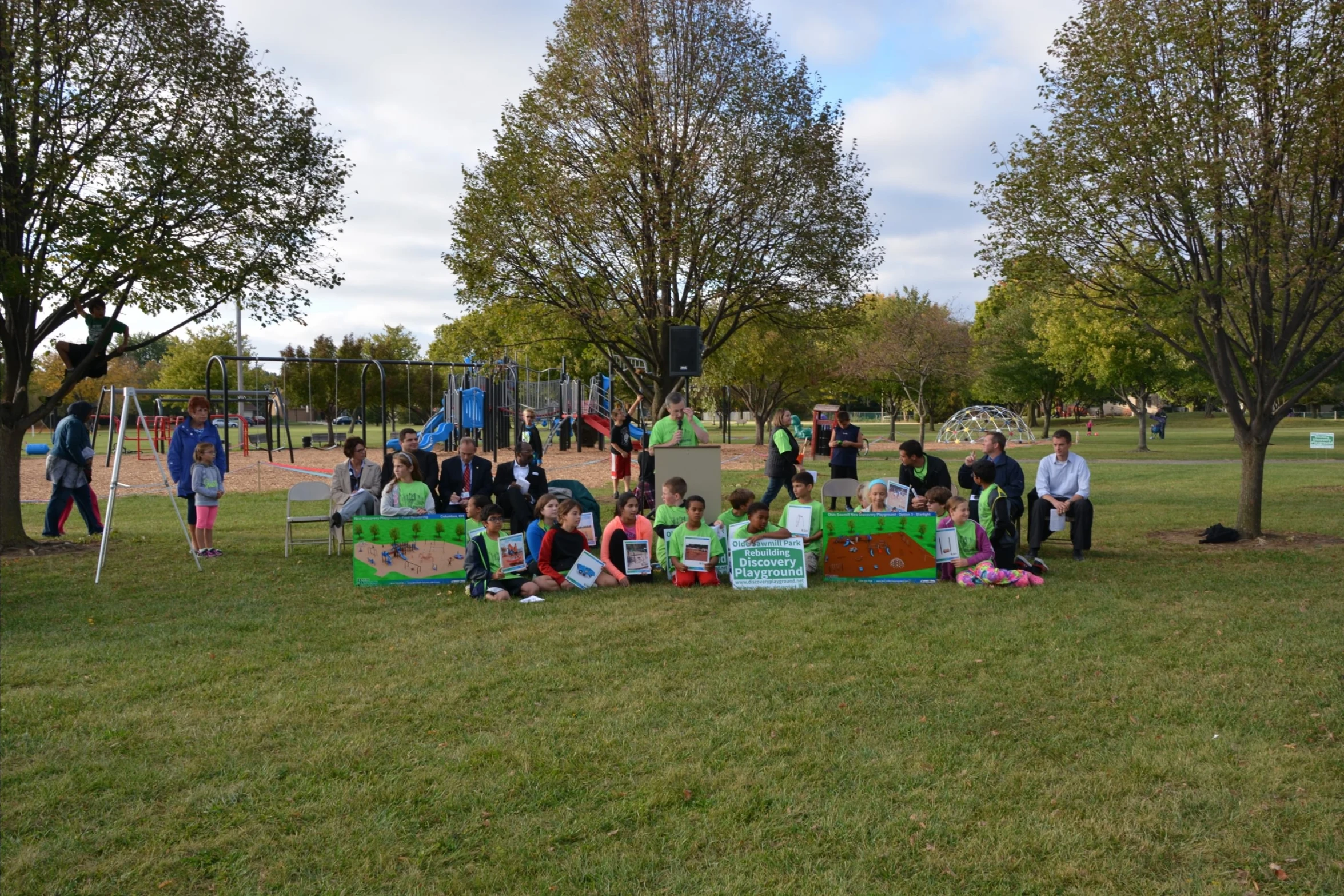 some children sitting on the grass at a park