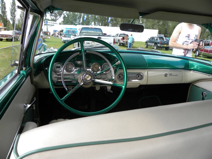 a vintage car with interior parked in a grassy field