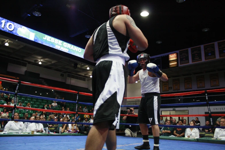 two men boxing with each other at an indoor arena