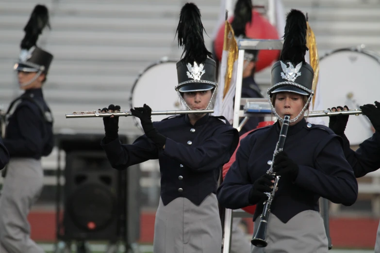 a trio of uniformed women holding music instruments