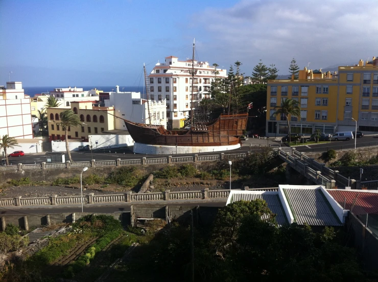 a wooden ship on top of a beach in town