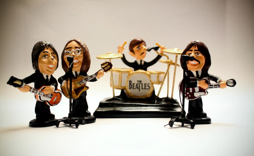 three bobble heads that have been designed to look like musicians