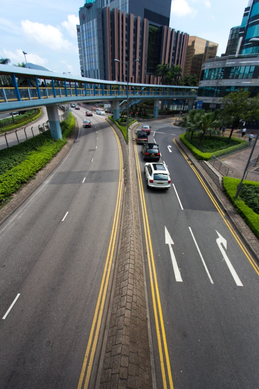 two trucks and a bus on an interstate with buildings