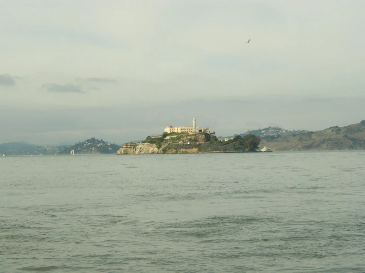 a island sits across the water from a white building