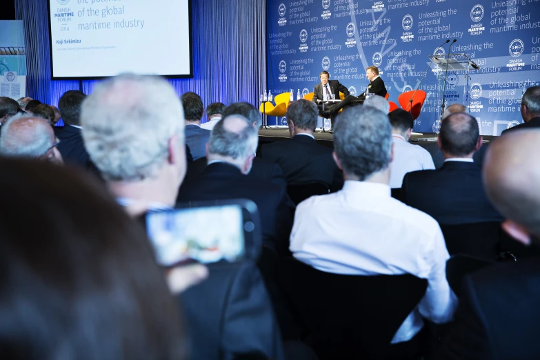 the woman is addressing her audience at the conference