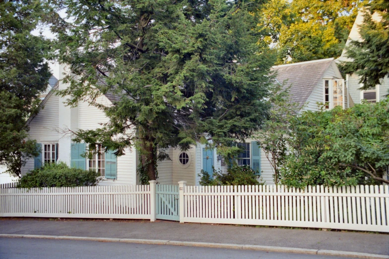 a white house with blue shutters and a white picket fence