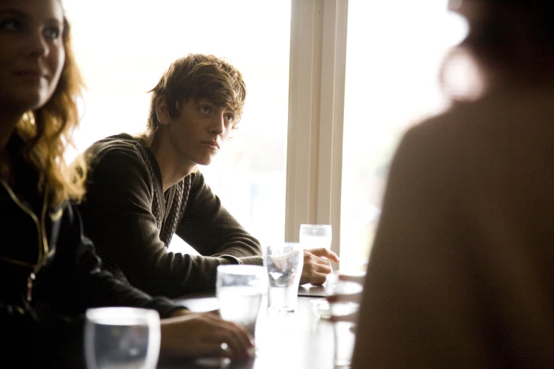 several people are sitting at a table with drinks