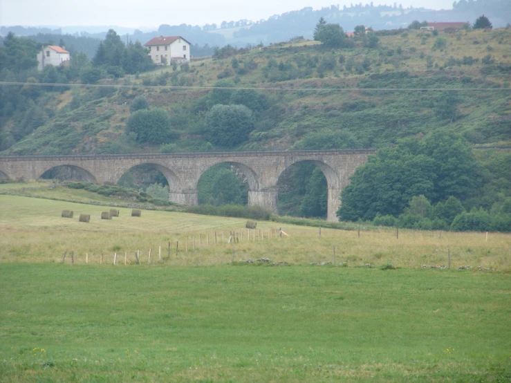 a long train passes over an old stone bridge