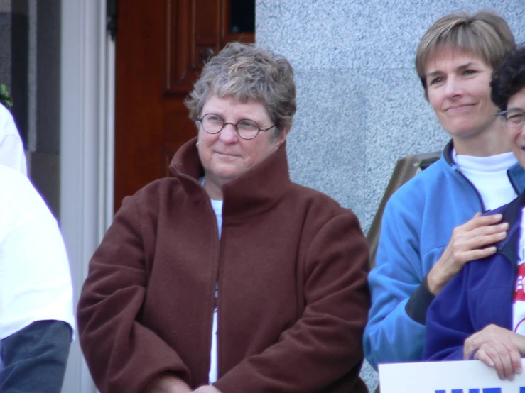 the women are holding a white sign near each other