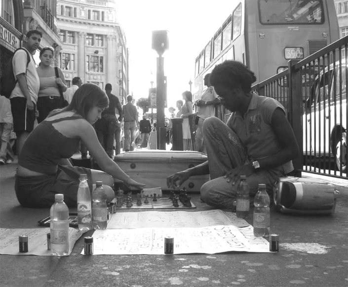 a couple of people sitting on top of a street