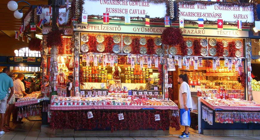 two people looking at goods on the shelves in a market