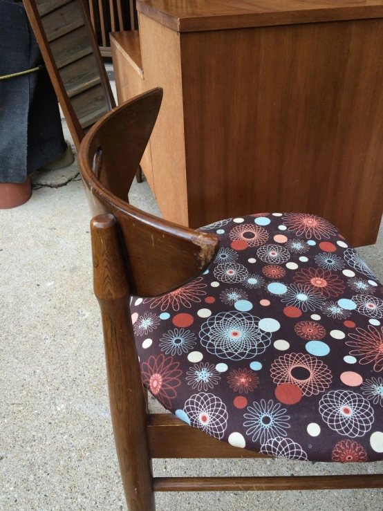 a wooden chair that is on the ground with a chair cover