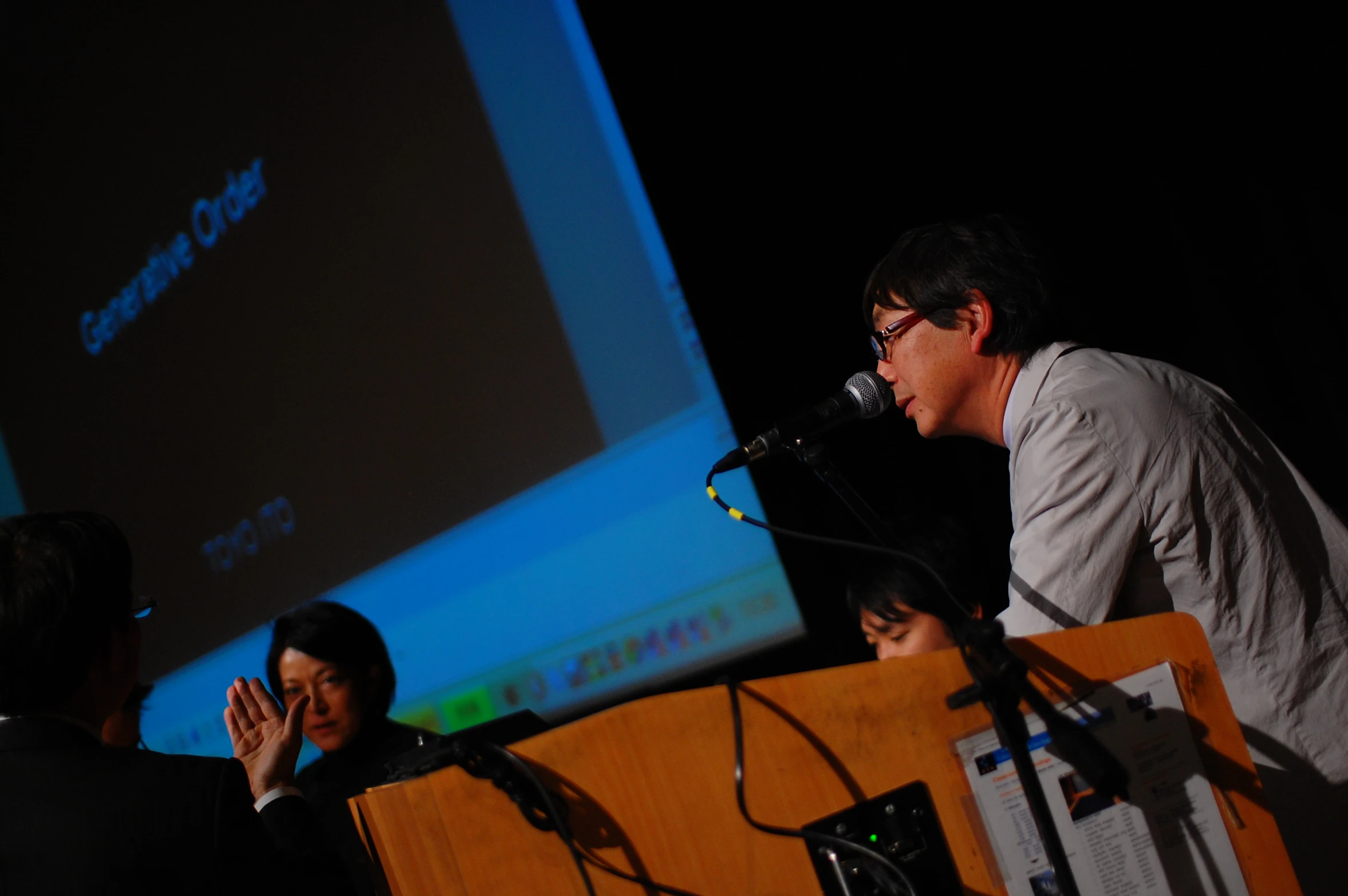 a man standing at a podium while holding a microphone