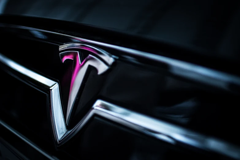 a tesla logo sits on the front grille of a car