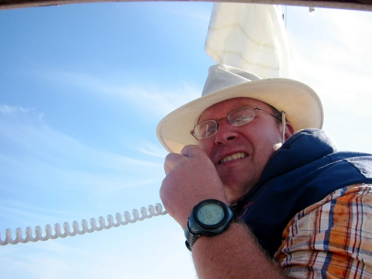 a man wearing a white hat is talking on his phone