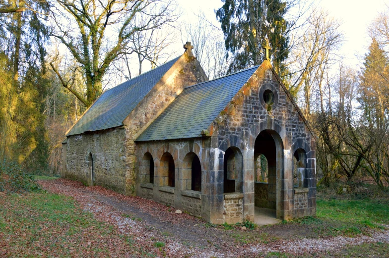 an old church standing in the middle of a forest