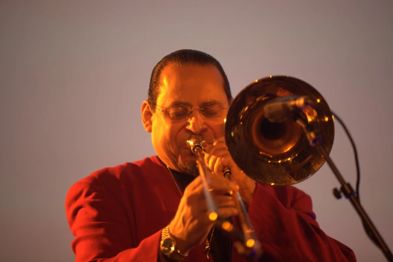 an indian man playing his trumpet on stage