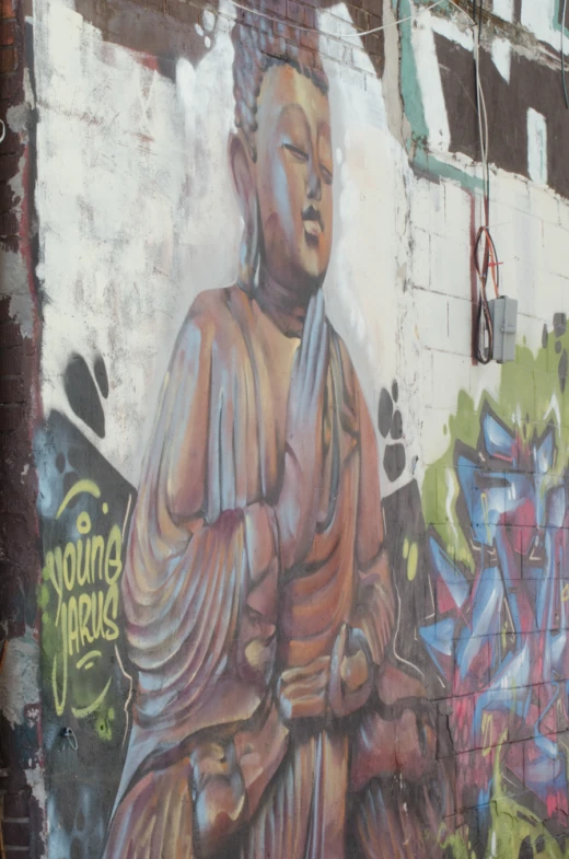 a large mural of a buddha statue painted on a wall