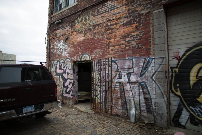 a truck parked next to a red building covered in graffiti