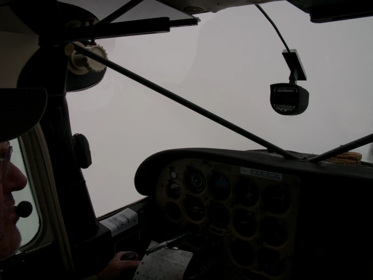 looking up at the front side of an airplane from a pilot cockpit