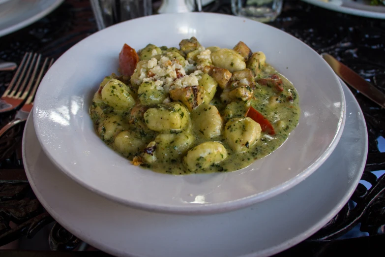 a white bowl filled with some food next to other plates