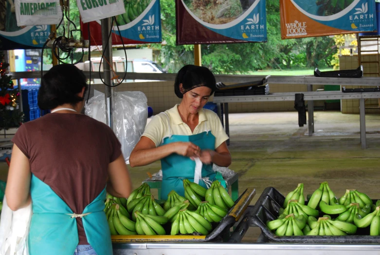 a woman preparing fresh green bananas for sale