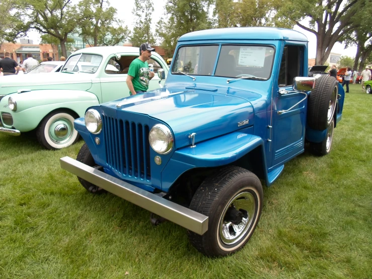 a light blue jeep parked in the grass