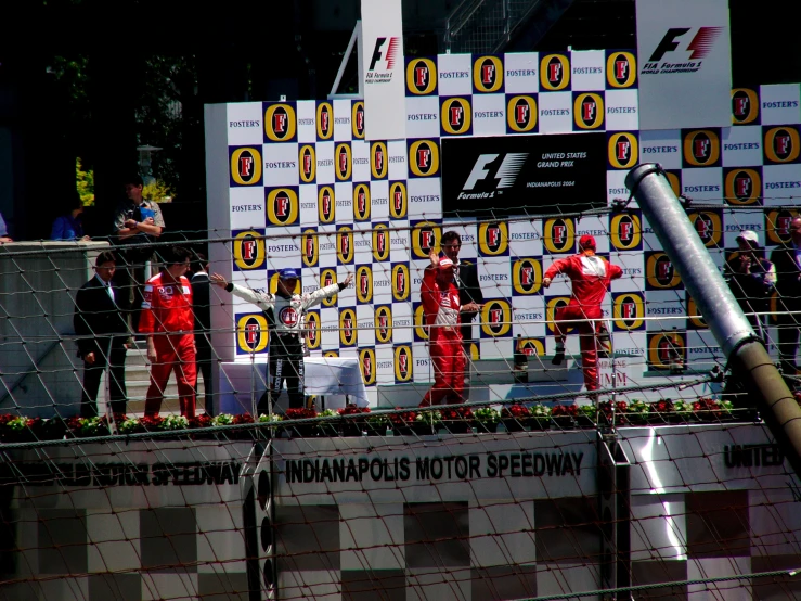 the race cars are lined up with the men in red on them
