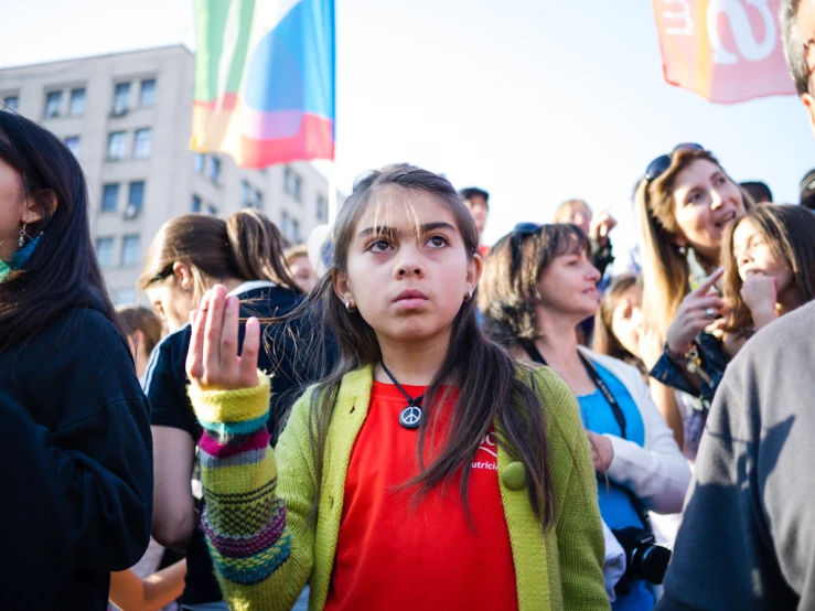 the woman in the red shirt is standing in front of the crowd