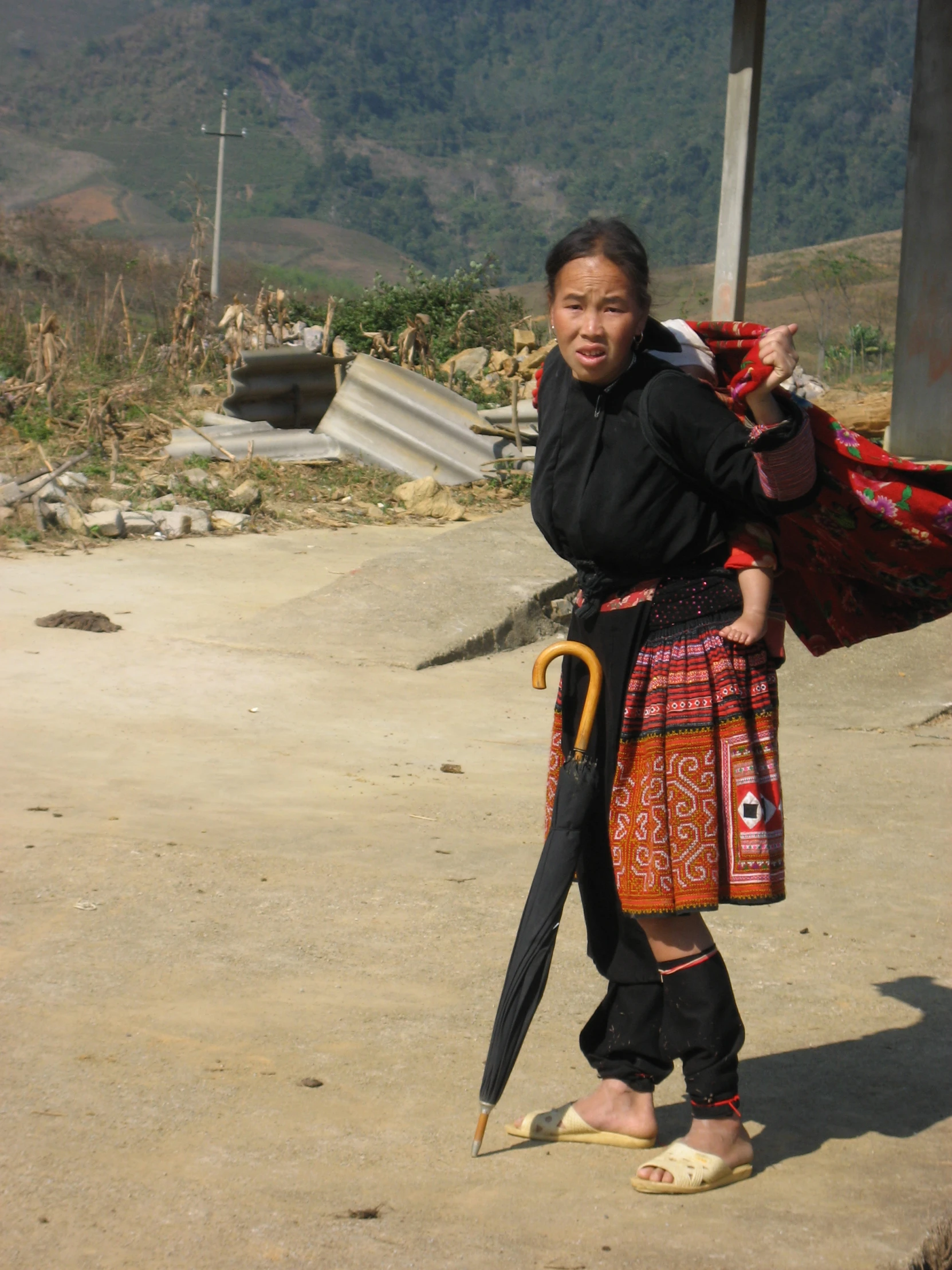 the woman is walking along the road carrying an umbrella