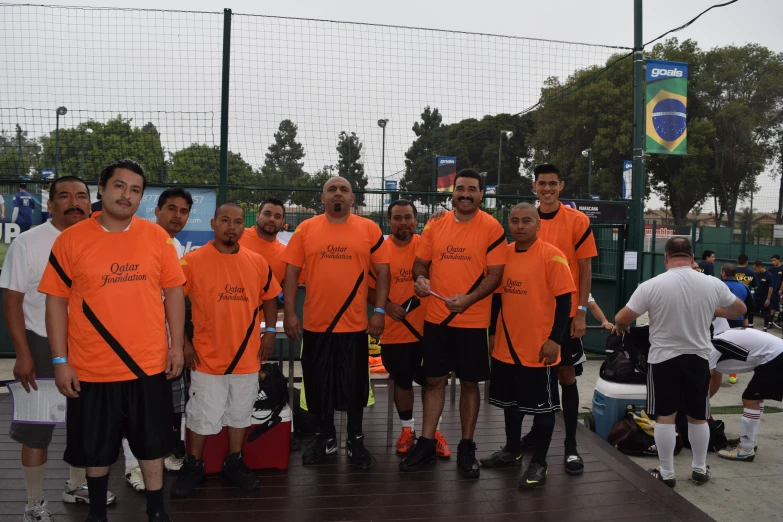 many people with tennis rackets standing in an area