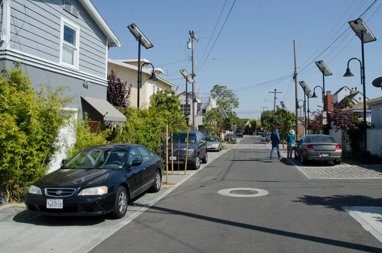 a black car parked on a narrow residential street