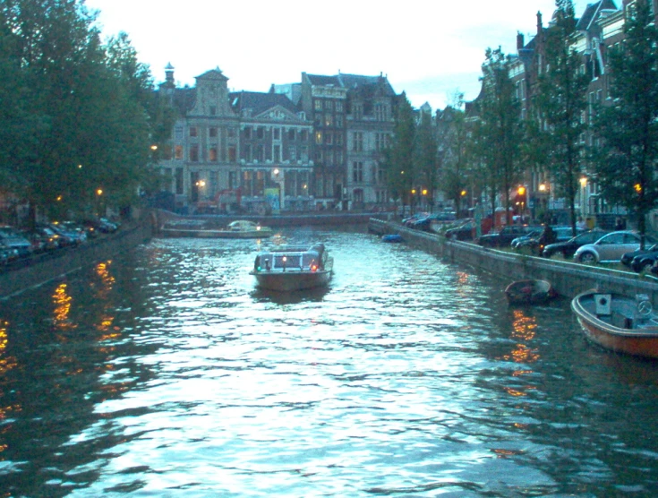 a couple of boats moving along a city canal