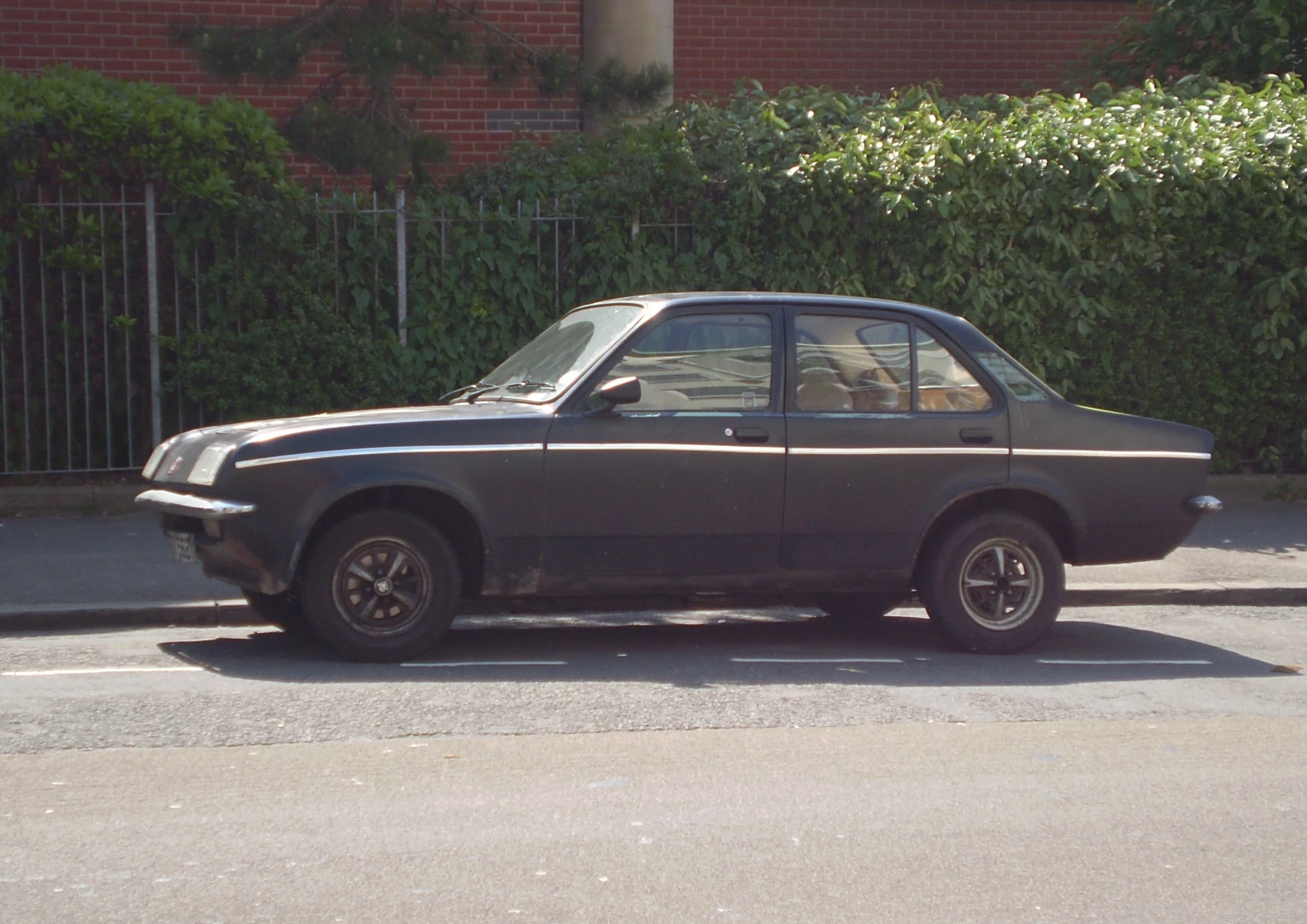 a dirty car sits parked on the street