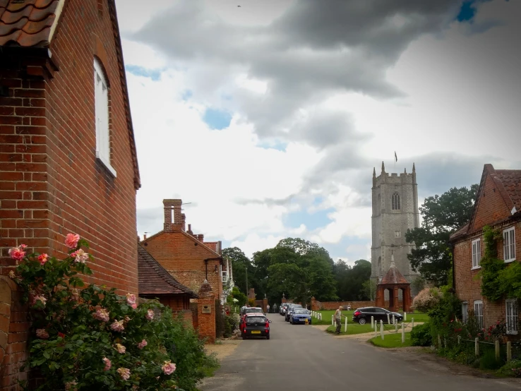a picture of a village street and a building with roses around it