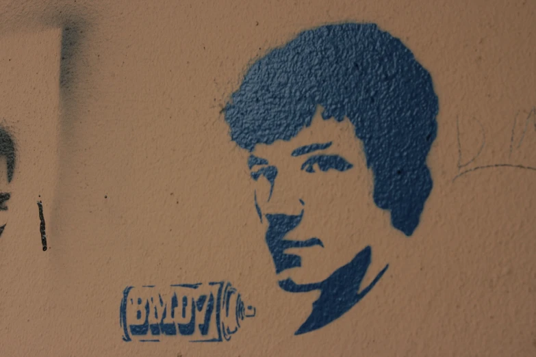 graffiti depicting a  next to another painting of a young man