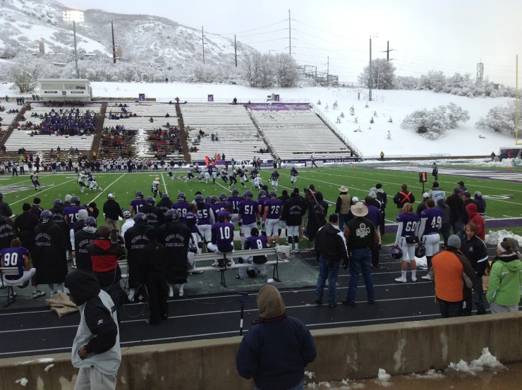 people are gathered on the sideline in a stadium for an event