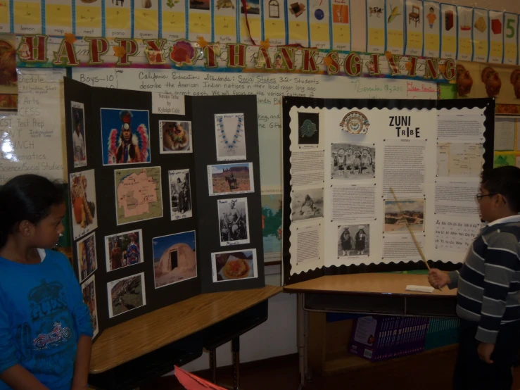 children in a class room near a poster and a blackboard