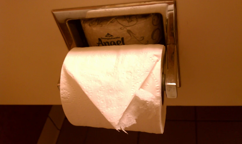 a roll of white linen in an empty metal holder