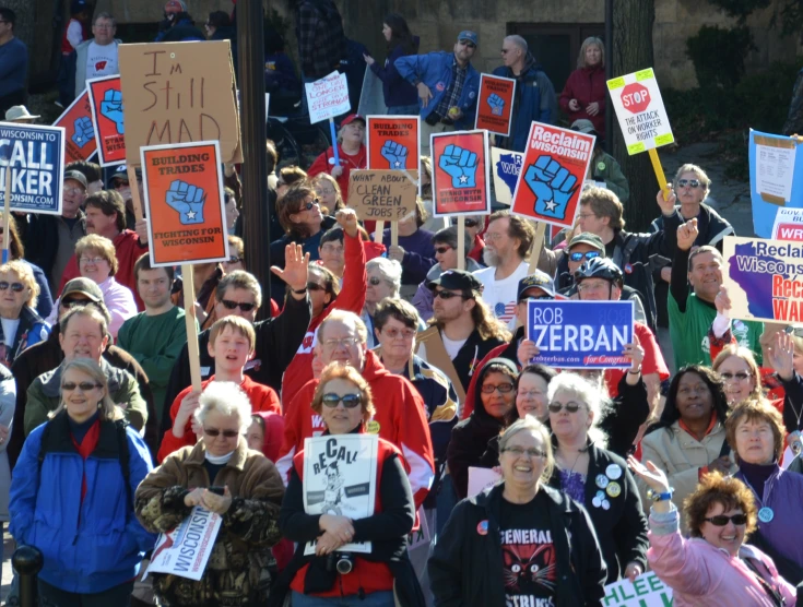 many people are holding signs in the street