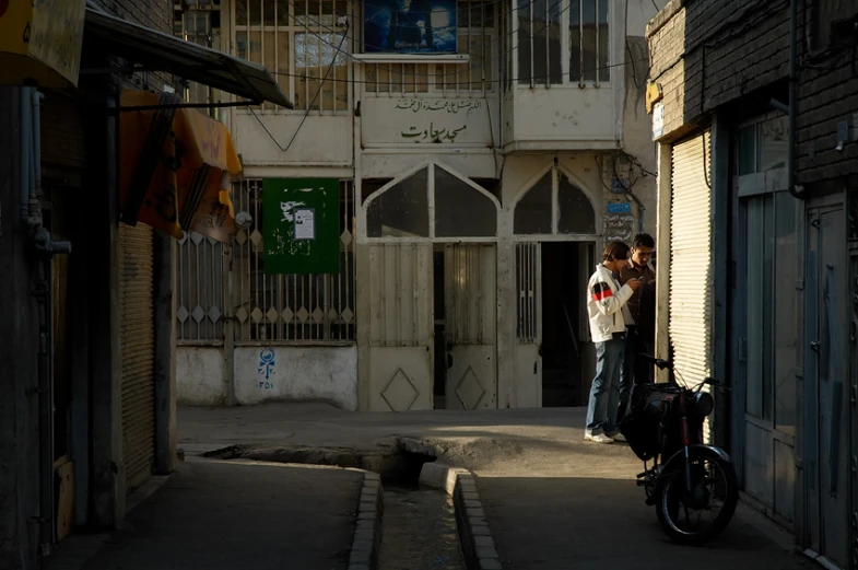 two people hug on the street in front of an old building