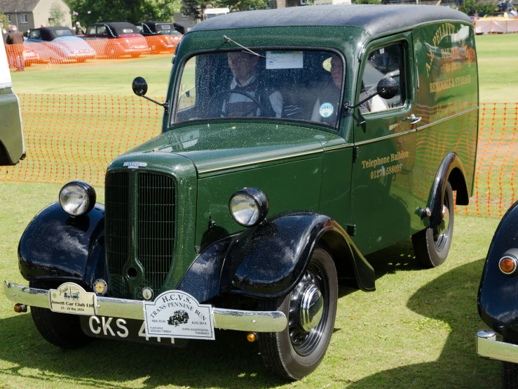 several antique trucks lined up on display on grass