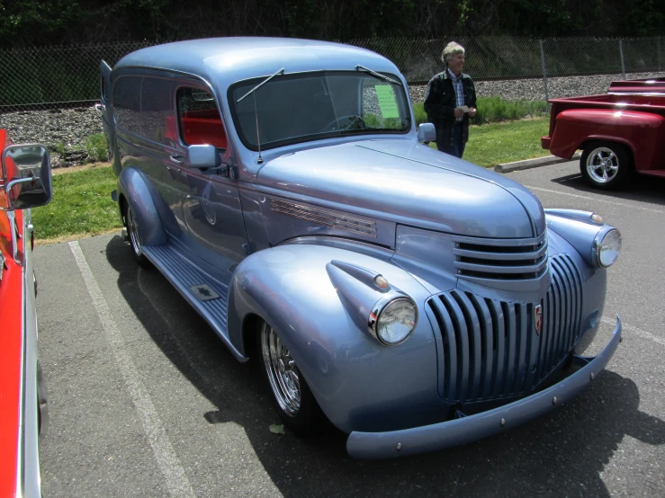 a shiny antique truck is parked in a parking lot