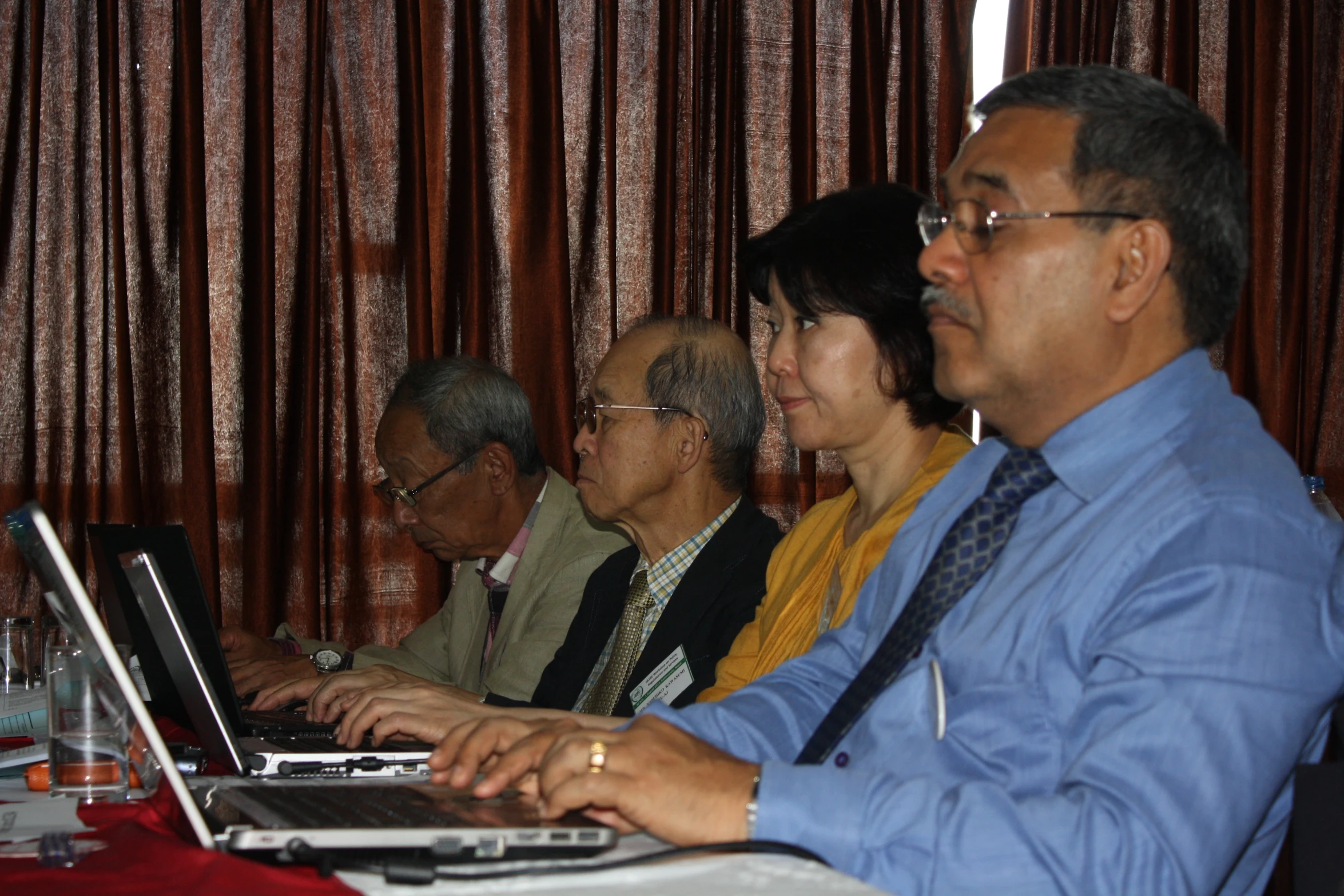 a man sitting at a table while using a laptop