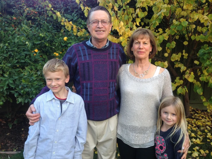 an old couple with their children in front of a bush