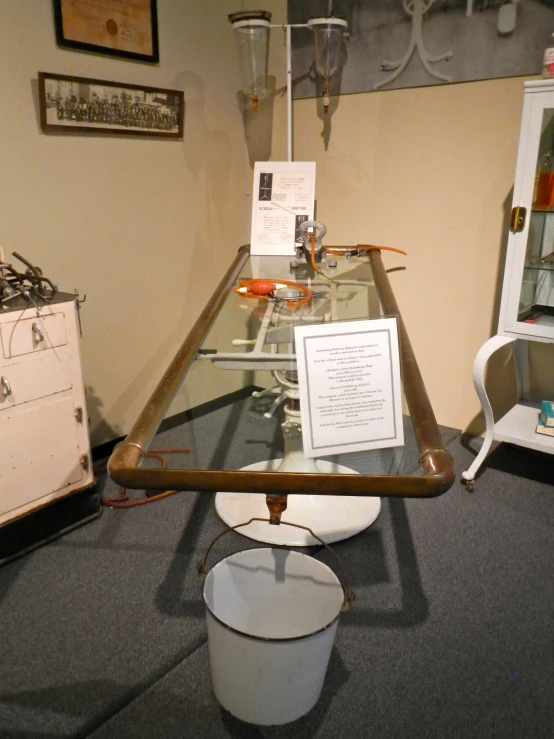 a long glass table with a white bucket on top of it