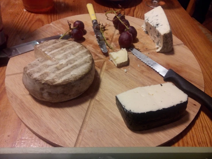 an overhead view of cheese and bread with wine on the side