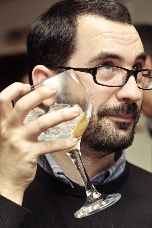 man wearing glasses with his hand resting on his neck