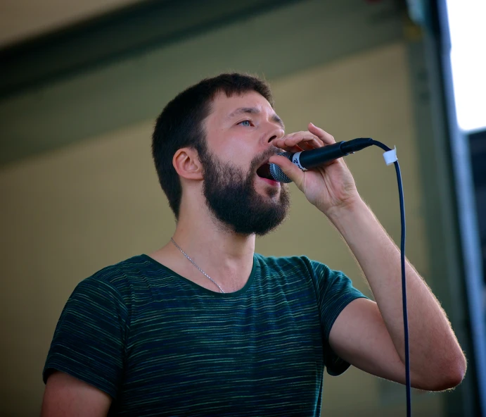 the bearded man is singing into a microphone