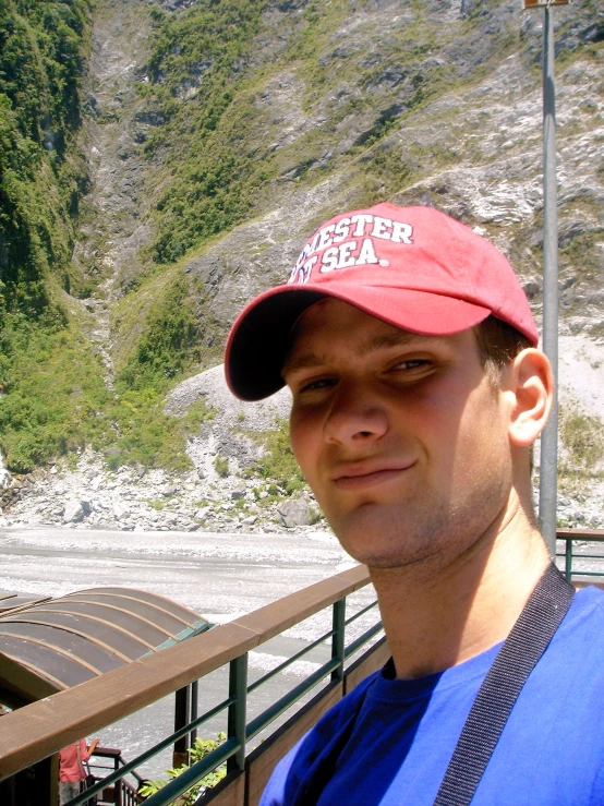 a man stands on a bridge next to a river